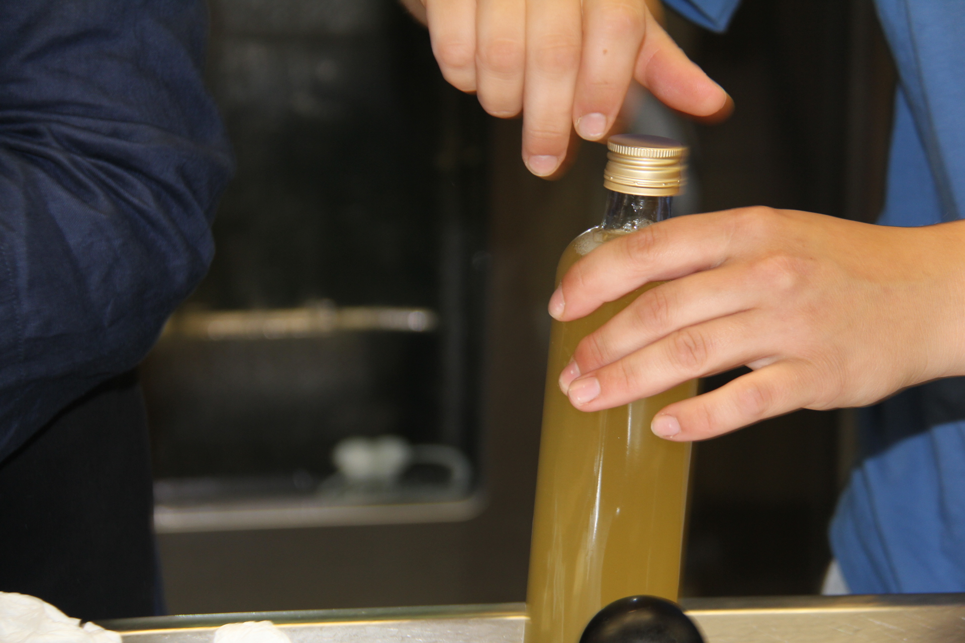 Eine Flasche wird von Hand verschlossen